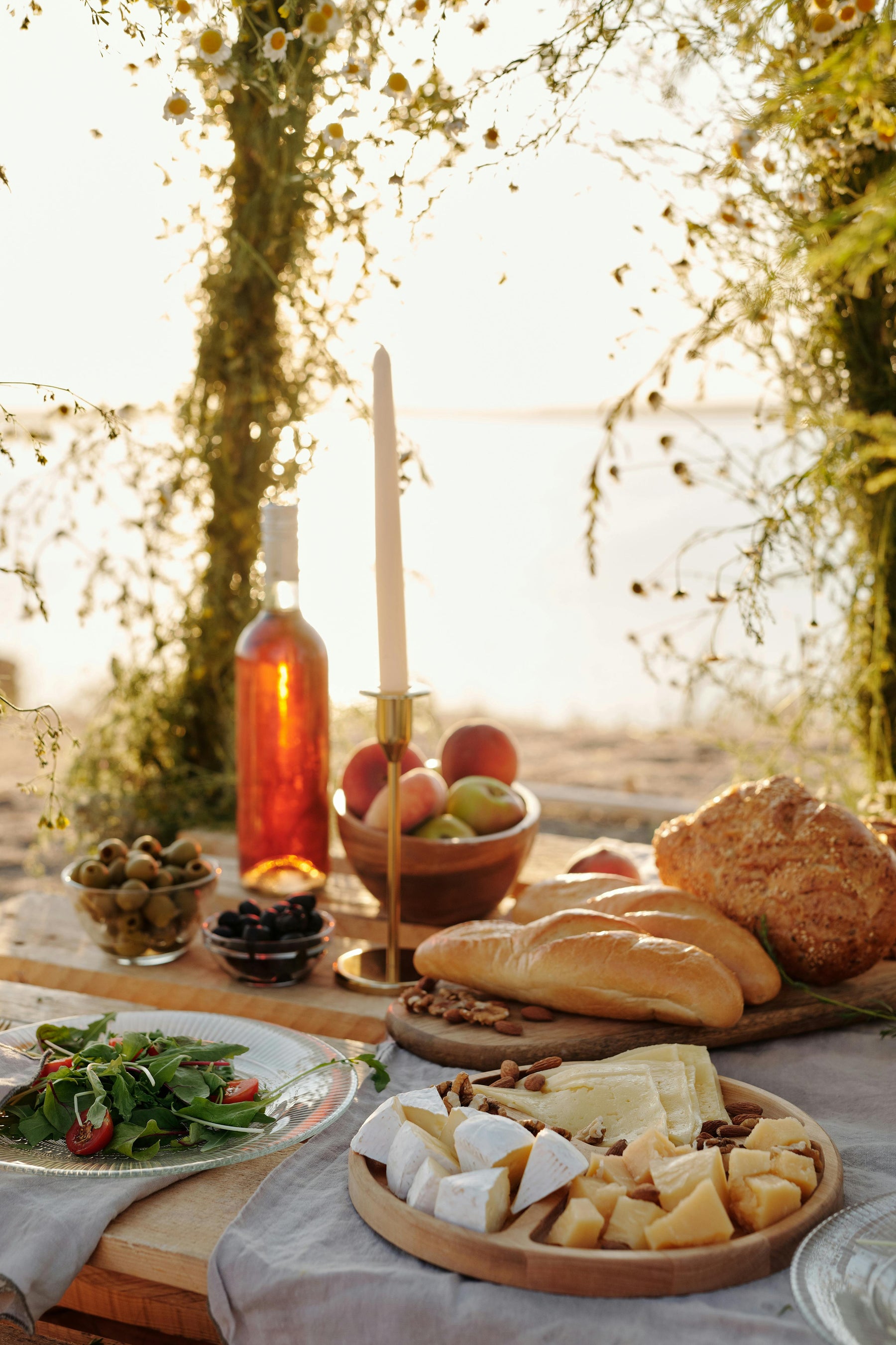 Outdoor scene charcuterie, bread, and wine adorns a gorgeous table in the Italian countryside